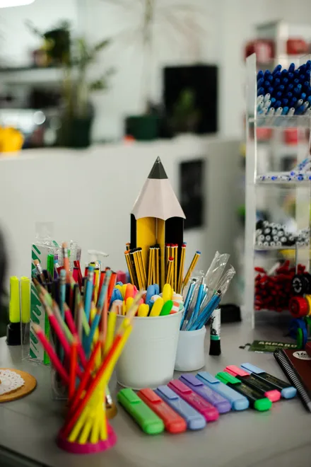 Copos com lápis e marcadores coloridos numa mesa da loja