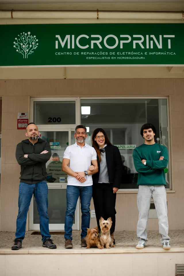 A equipa da Microprint, com dois cães, em frente à loja