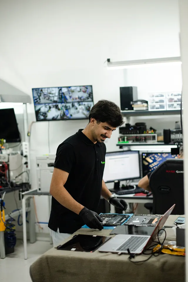 Técnico de luvas a trabalhar num portátil na bancada