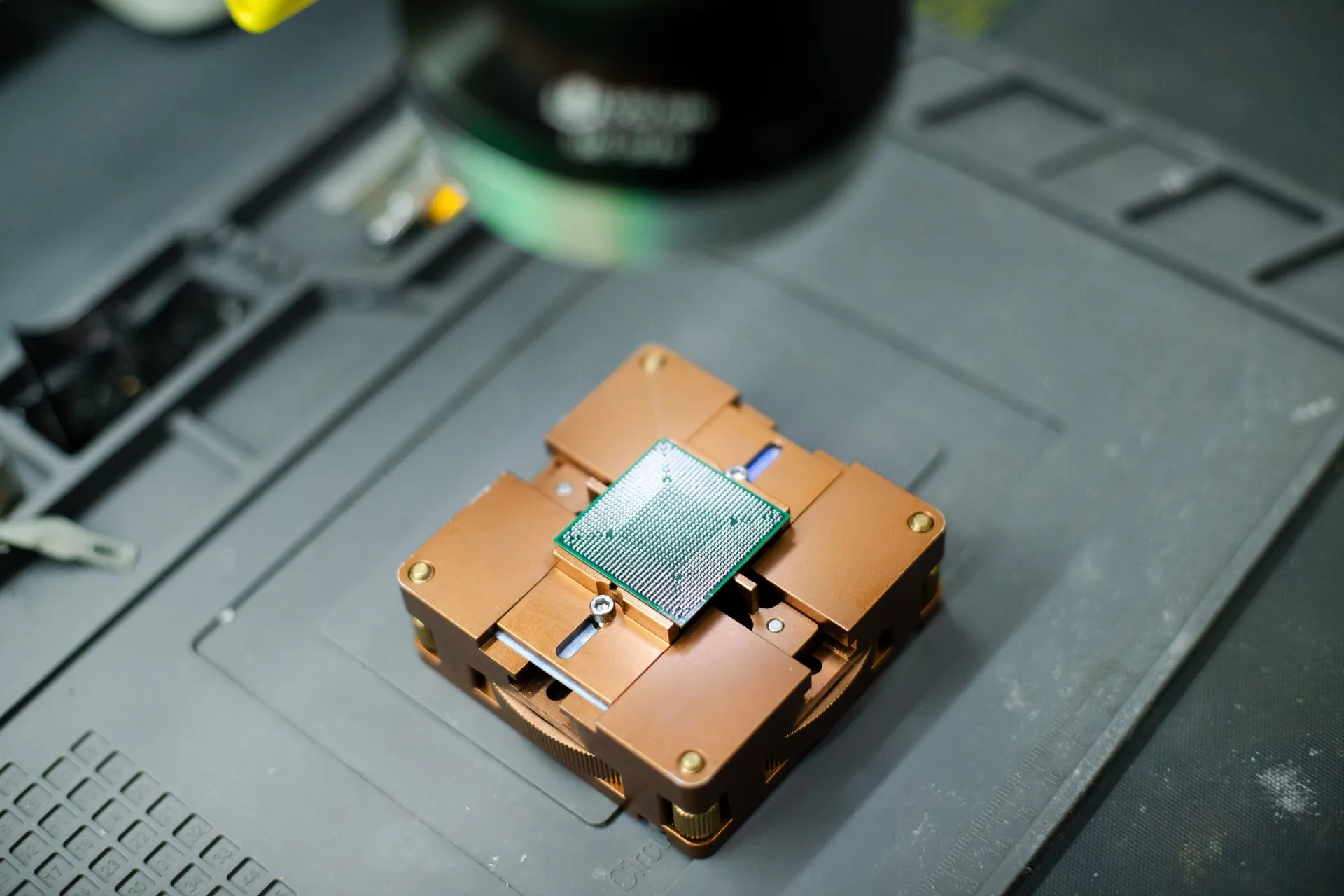 Chip BGA montado num suporte de reballing, sobre a bancada